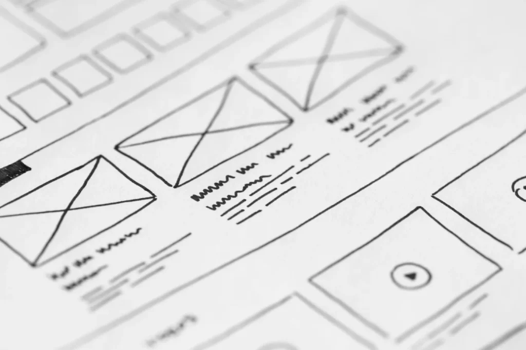 Hand-drawn website wireframes on paper.